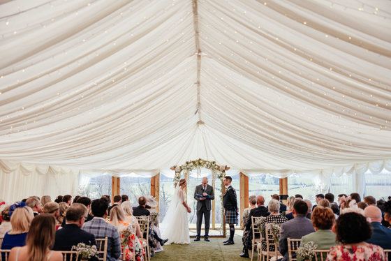 Bride and groom at altar whilst guests look on